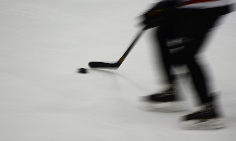 hockey player shooting a puck