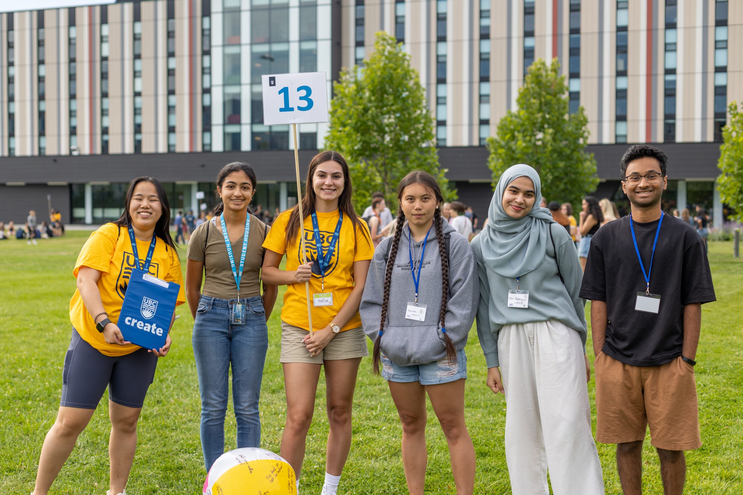 Six UBCO students posing and smiling outside Nechako Residence, as they celebrate Create new student orientation.