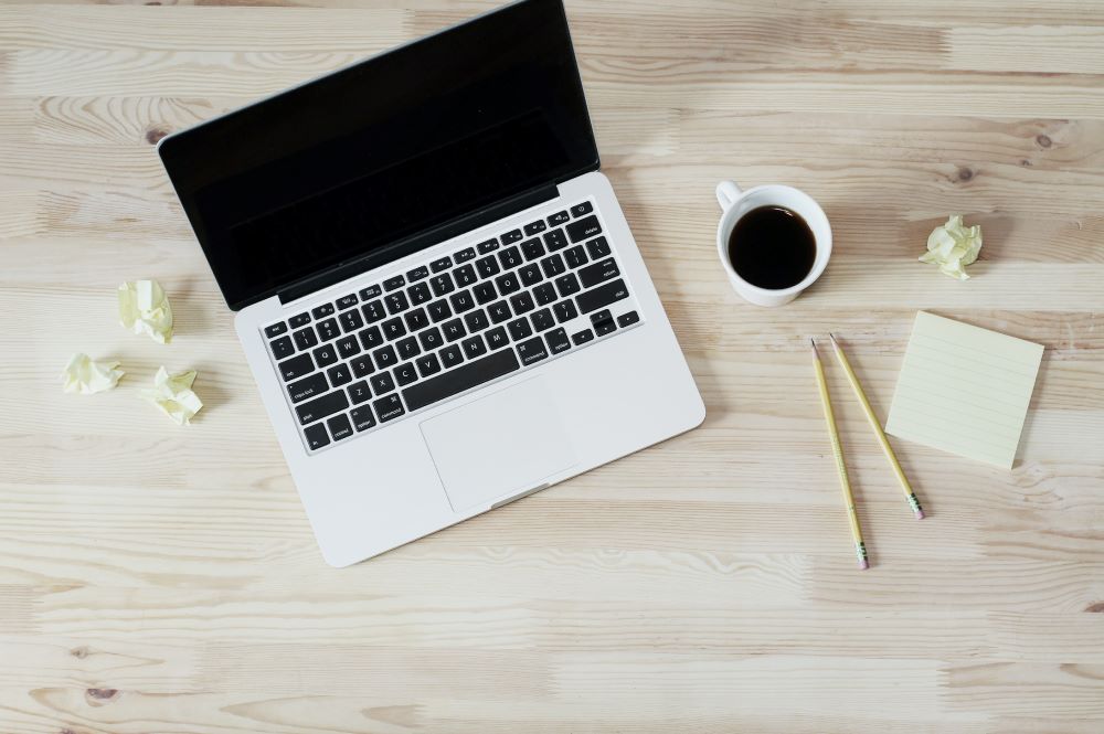 Aerial shot of a laptop and cup of coffee.