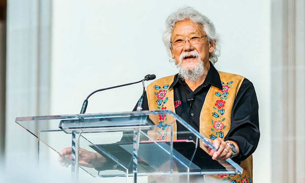 A photo of David Suzuki standing at a podium.