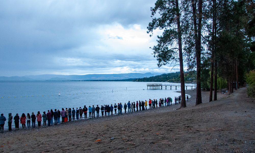 A row of people on the beach.