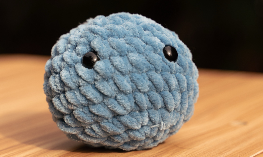 Blue crochet stress ball with black eyes